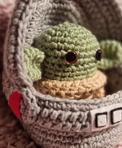 Photograph of crocheted Grogu ('The Mandalorian') in his pod, Handmade by Rimabella.