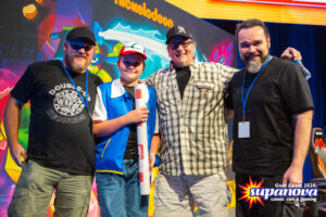 Supa-Star Jon Sommariva standing next to a fan dressed as Ash Ketchum from 'Pokemon', next to 'Teenage Mutant Ninja Turtles' co-creator Kevin Eastman, and international artist Freddie Williams II.